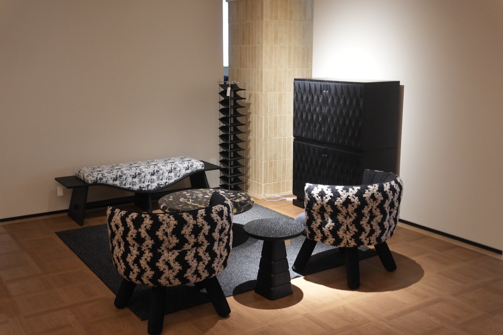 Patterned upholstered lounge chairs with a dark sculptural side table